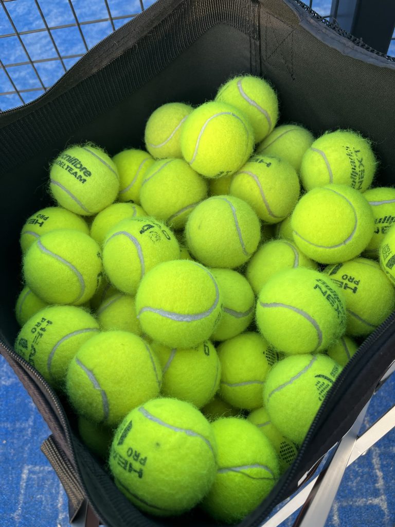 pelotas en un carro de entrenamiento de pádel